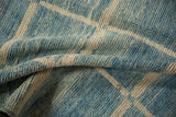 Plush texture of modern Afghani rug with ivory geometric lines and blue striations.