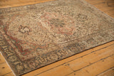 Angled perspective on a distressed Malayer rug showing its large medallion and time-softened colors.