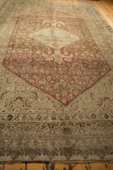 Angled view along the length of a distressed antique Bijar, showcasing the time-softened Herati field.