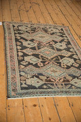 Distressed Hamadan rug pile, geometric vine patterns in charcoal, melon, silver; visible wear.