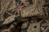 Vintage distressed Hamadan rug's worn pile, featuring charcoal, silver, and dusty melon geometric patterns.
