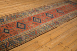 Angled view showing the repeating column of diamond medallions on the antique Northwest Persian runner.