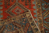 Folded corner on an antique Persian rug reveals the hand-knotted reverse and side cord selvage.