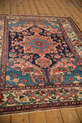 Low perspective across a vintage Bakhtiari rug, detailing floral motifs on its deep navy blue field.