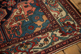 Corner spandrel of a vintage Persian Bakhtiari rug showing interconnected vines and floral motifs.