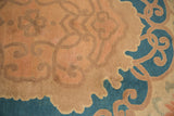 Detail of antique Chinese Arts and Crafts rug: pale mauve scrolling vines, dusty blue field.