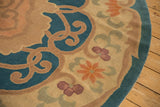 Curvilinear scrolling vines, tangerine, mauve blossoms on denim blue antique Chinese carpet.