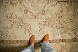 Distressed Kars carpet, ivory and beige field, faded floral sprays, soft texture.