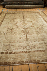 Distressed vintage Kars rug border with geometric pattern, faded floral field, and fringe.