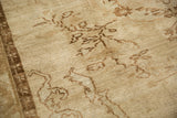Detail of vintage Turkish Kars carpet: worn beige pile, brown floral sprays, and partial border.