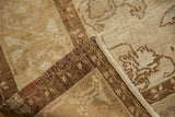 Distressed vintage Kars carpet with beige pile and prominent brown machine-bound edge.