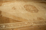 Angled view of the octagonal medallion and stepped spandrels of a distressed Kars carpet.