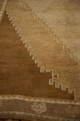 Detail of a stepped corner spandrel showing abrashes in bronze-brown and sand tones.