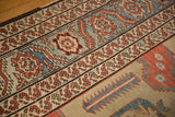 Meandering serrated leaf and palmette border in powder blue and terracotta on an antique carpet.