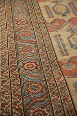 Angled close-up of the meandering palmette border next to the ivory field on a Persian Bakshaish carpet.