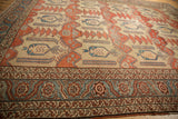 Angled view of the serrated palmette border and worn, hand-knotted pile on an antique Bakshaish.