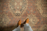 Distressed Sparta carpet featuring faded madder root red field with oxidized silver and beige vine motifs.