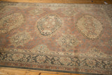 Distressed vintage Sparta carpet, faded madder red field with medallions and traditional Turkish borders.