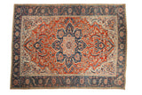 Distressed vintage Ahar carpet with a starburst medallion and scrolling vines in brick red and navy blue.