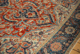 Close view of the distressed low-pile texture showing red and navy blue floral vine motifs.