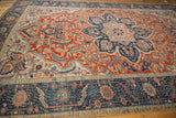 Angled view showcasing the decorative texture and scrolling vines of a distressed vintage Ahar carpet.