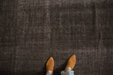 Detailed texture of a vintage Turkish kilim showing its abrash ground in dark chocolate brown and silver.