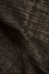 Abrashed texture of a hand-woven Turkish kilim in dark brown and silver.