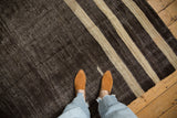 Vintage Turkish Kilim carpet with charcoal brown black and ivory striped pattern and textured weave.
