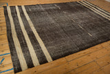Abrashed charcoal brown-black field with subtle ivory wave patterns on a vintage Turkish Kilim.