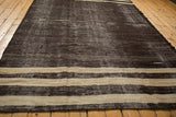 End of a vintage Turkish Kilim showing textured horizontal bands in charcoal and ivory.