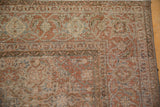 Distressed vintage Tabriz carpet's corner, featuring Herati motifs, spiraling vines, and worn texture.