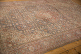 Faded Herati pattern in slate blue and cherry red on a distressed Tabriz carpet.