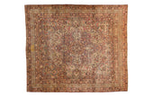Antique Kerman carpet with a scalloped medallion and scrolling arabesques in cochineal red and navy blue.