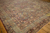 Intricate corner spandrel and floral borders of an early 20th century Persian Kerman carpet.
