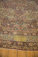 Knot heads and foundation visible in a worn area of a floral antique Kerman carpet.