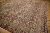 The ornate corner spandrel and intricate floral borders of a hand-knotted antique Kerman carpet.