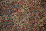 Detailed close-up of the worn pile on an antique Kerman, revealing intricate arabesques and knot heads.