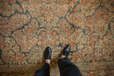 Distressed Persian Sarouk carpet, rich floral patterns with time-softened red and blue tones.