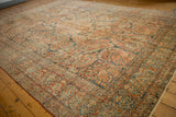 Corner detail of distressed Sarouk rug, faded red and blue floral motifs, with foundation showing.