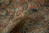Distressed floral motifs and worn pile on a hand knotted Persian Sarouk rug.