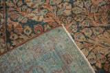 Distressed Sarouk carpet pile showing floral pattern wear, machine-bound edge, and woven foundation.
