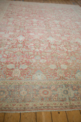 Distressed vintage Mahal carpet detail: interconnected floral blossoms, ruby red, dusty blue, and foundation showing.