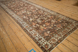 Angled perspective of a vintage Malayer runner showing the allover botanical pattern and distressed texture.