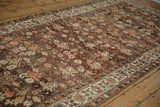 Detailed floral motifs on the abrashed charcoal and burgundy ground of a vintage Malayer runner.