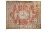 Vintage distressed Veece carpet with a hexagonal medallion on an abrashed brick red field with seafoam green accents.