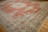 Angled view of the corner spandrel and border on a distressed vintage Persian Veece carpet.
