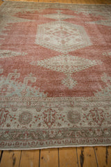 A low angle showing the worn pile texture and border details on a distressed vintage Veece carpet.
