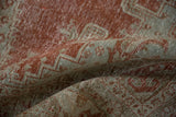 A soft fold showing the distressed, low-pile texture in brick red and silver-green.