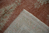 A folded corner shows the detailed hand-knotted foundation of the distressed Veece rug.