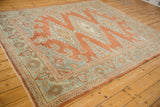 A vintage distressed Veece carpet from an angle, showing its abrashed rust and powder blue pattern.